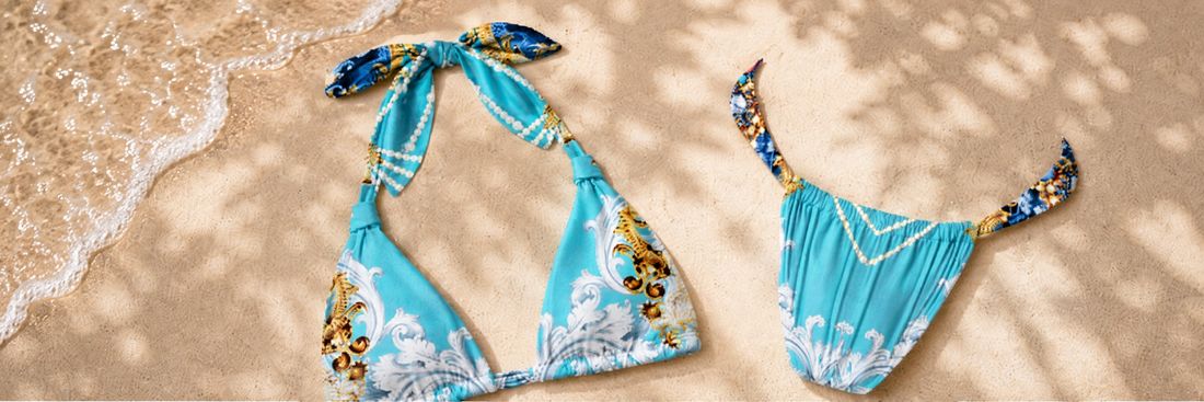 Swimwear — printed bikini top and bottom laid on sand at the shoreline