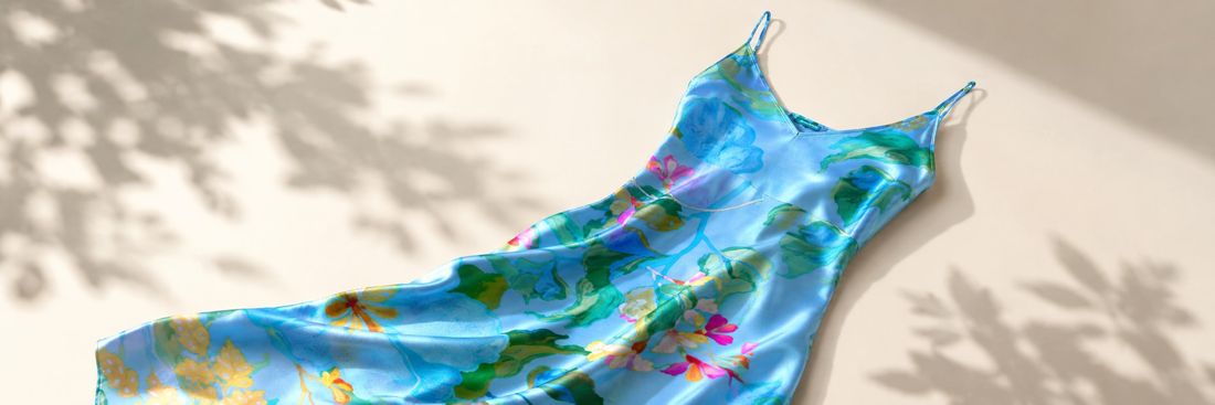 Womenswear — printed silk slip dress laid flat outdoors